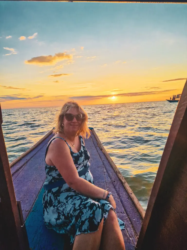 Em on a boat at sunset on Tonle Sap lake