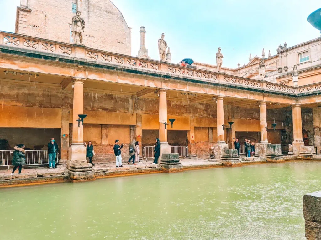 Green water in front of a colonaded walkway