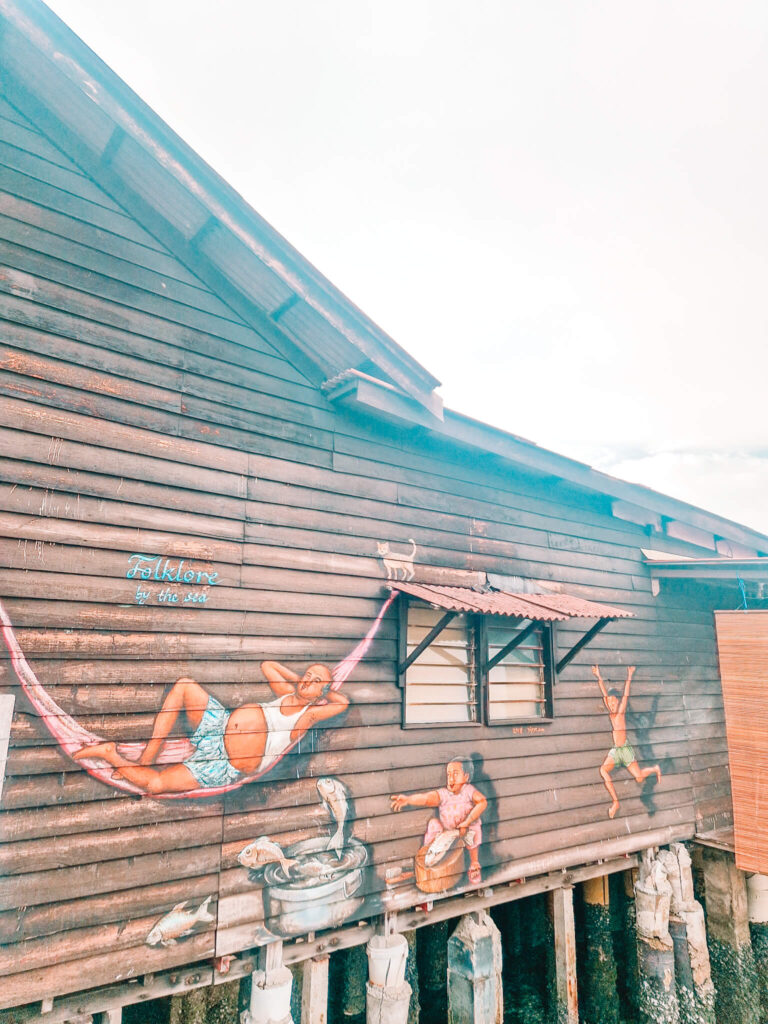 Street art of man in hammock and children, on wooden building