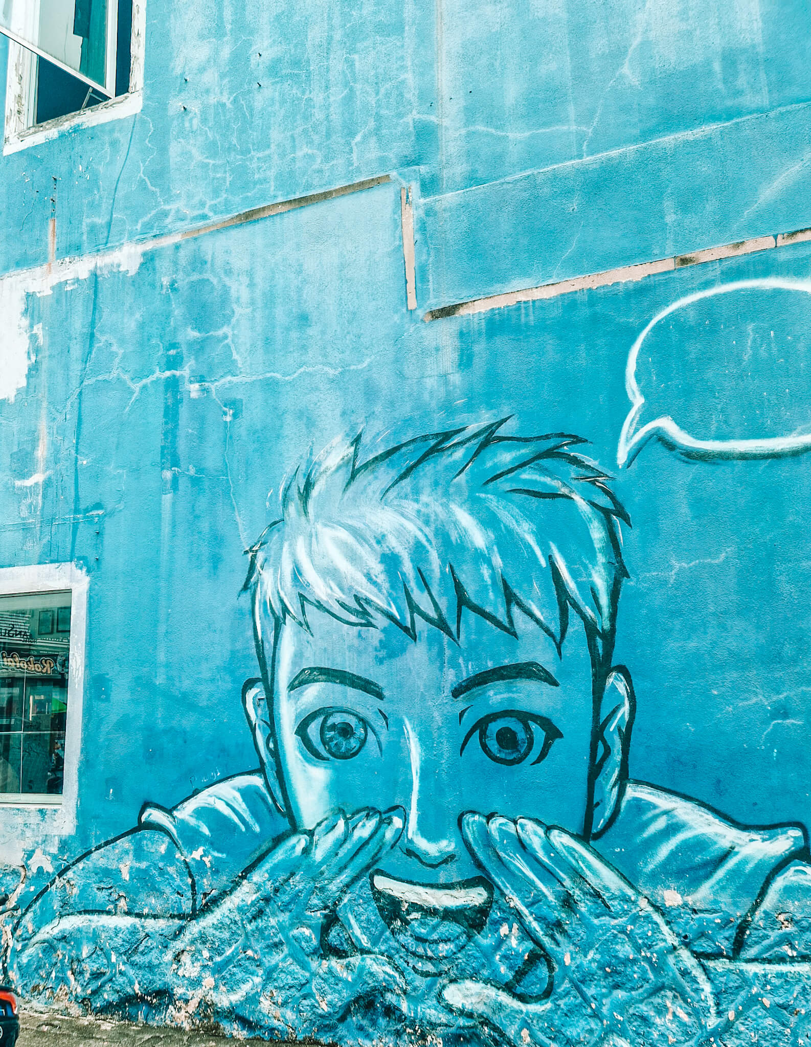 Blue street art of young boy's face