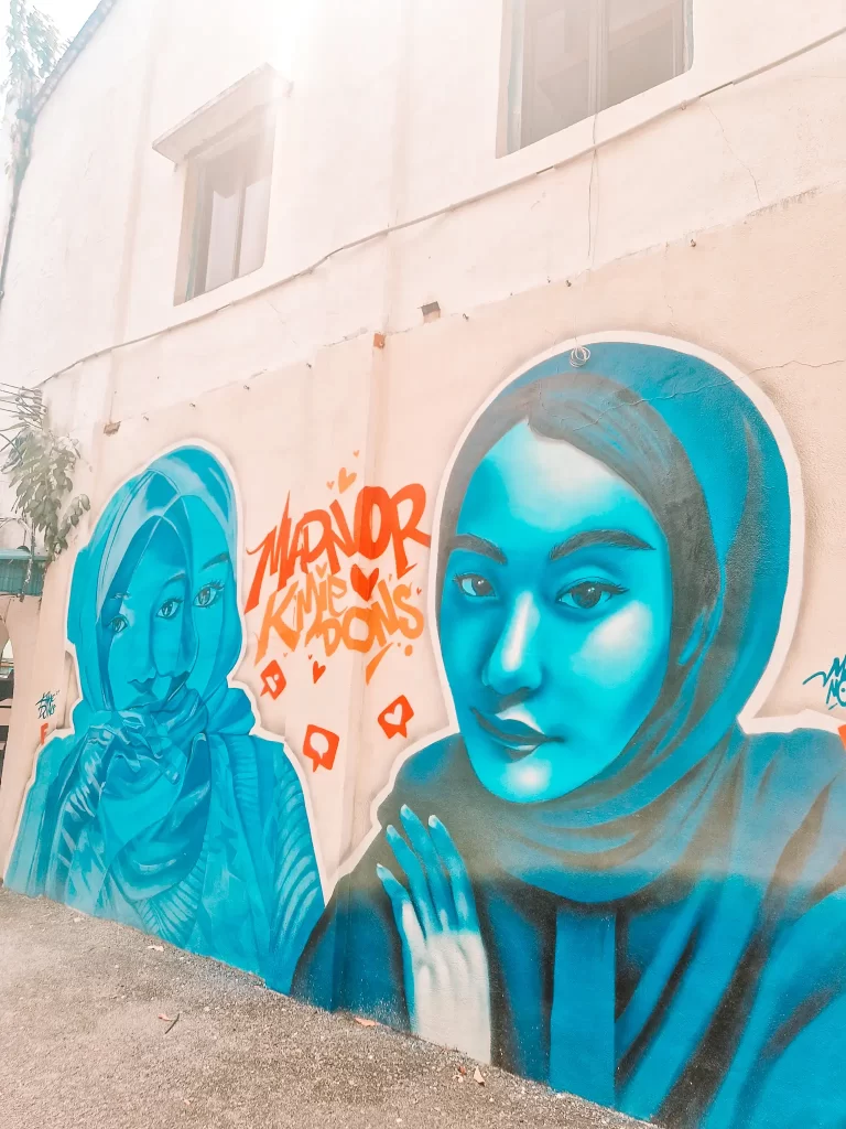 Street art of a blue woman wearing a hijab