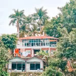 Hotel on lake surrounded by palm trees and greenery