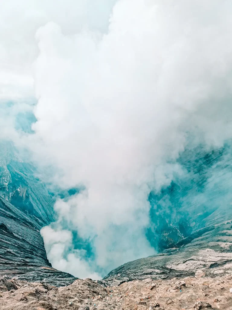 A breathtaking view of Mount Bromo’s active crater, with dense volcanic smoke rising from its depths—a must-see highlight on any Mount Bromo itinerary.