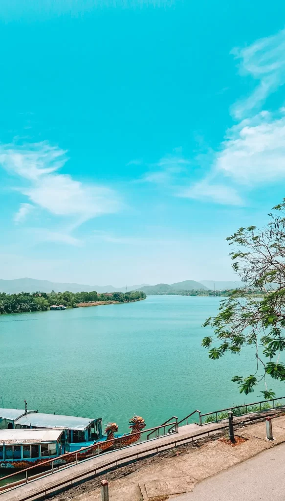 Bright view of dragon boats docked on the Perfume River under a vivid blue sky, an iconic sight you’ll likely encounter during 2 days in Hue.