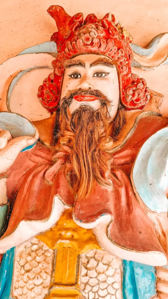 Close-up of a vibrant statue with detailed facial features and real hair beard, representing traditional craftsmanship seen during 2 days in Hue.