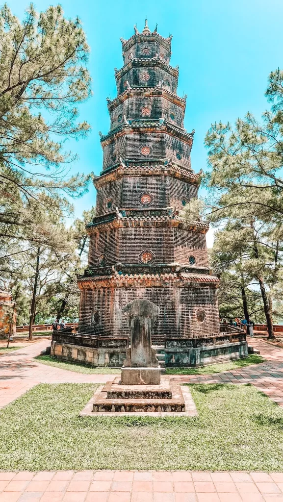 The iconic Thien Mu Pagoda standing tall among pine trees under a clear blue sky, a historic and spiritual landmark not to miss on your 2 days in Hue.