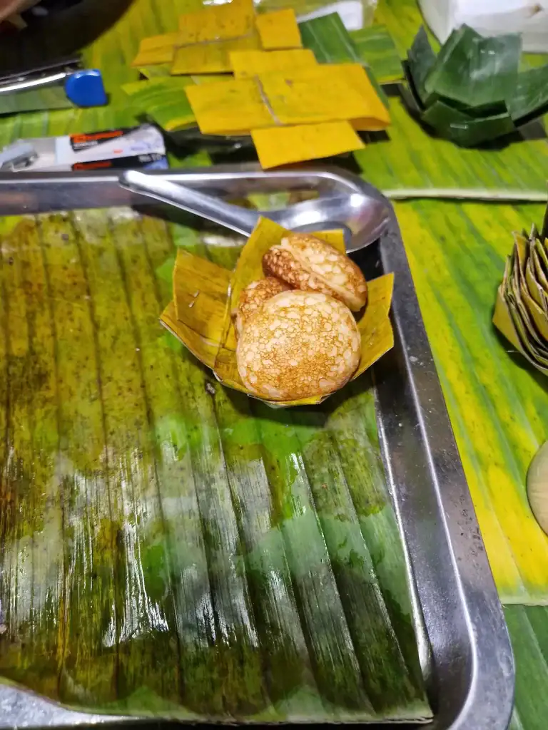 Freshly made kanom krok served in a folded banana leaf at a Luang Prabang market, offering an authentic street food experience among the best things to do in Luang Prabang.