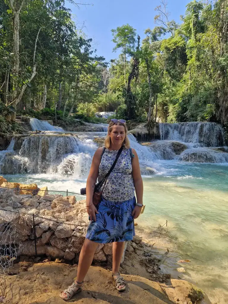 Em poses in front of the turquoise pools and cascading tiers of Kuang Si Waterfalls, a must-visit attraction among the best things to do in Luang Prabang