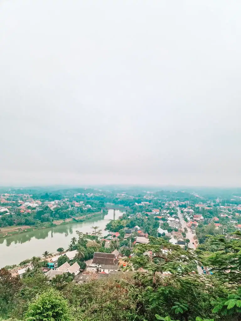A wide-angle view of Luang Prabang from the top of Mount Phousi, showing the town’s rooftops and the Mekong River—an iconic photo spot and one of the best things to do in Luang Prabang.