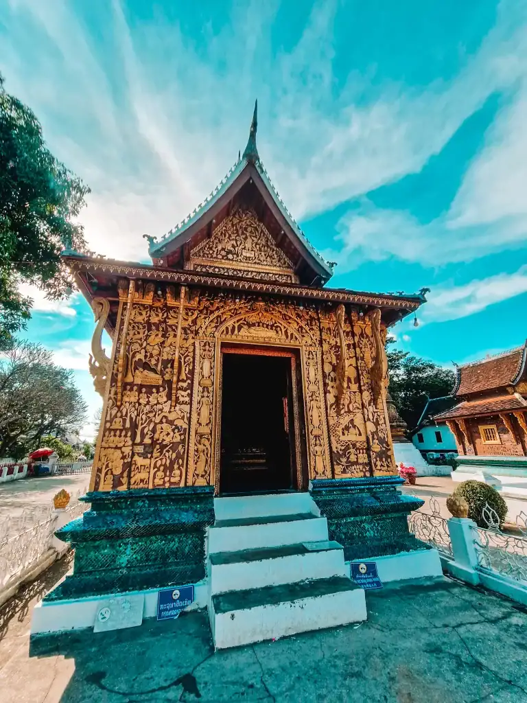 A beautifully adorned golden temple entrance at Wat Xieng Thong, highlighting sacred architecture that ranks high on the list of best things to do in Luang Prabang.