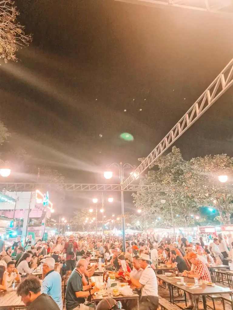 A packed food court at Luang Prabang night market buzzing with diners under string lights, capturing the festive energy of one of the best things to do in Luang Prabang.