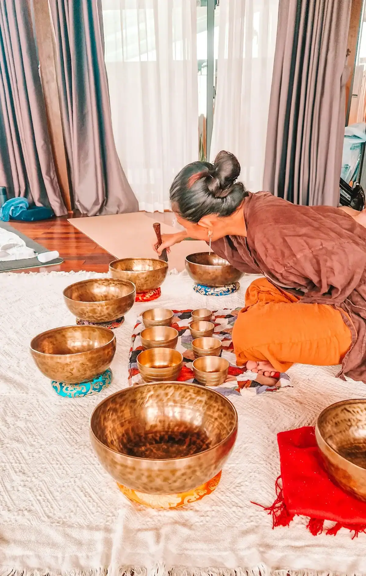 A wellness practitioner using Tibetan singing bowls in a sound therapy class, offering a deeply relaxing and unique thing to do in Da Nang for holistic healing enthusiasts.