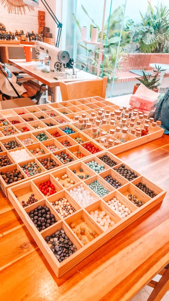 A creative craft station in Da Nang showcasing trays of colorful beads and glass jars beside a sewing machine—highlighting a hands-on workshop, one of the unique things to do in Da Nang for art lovers.