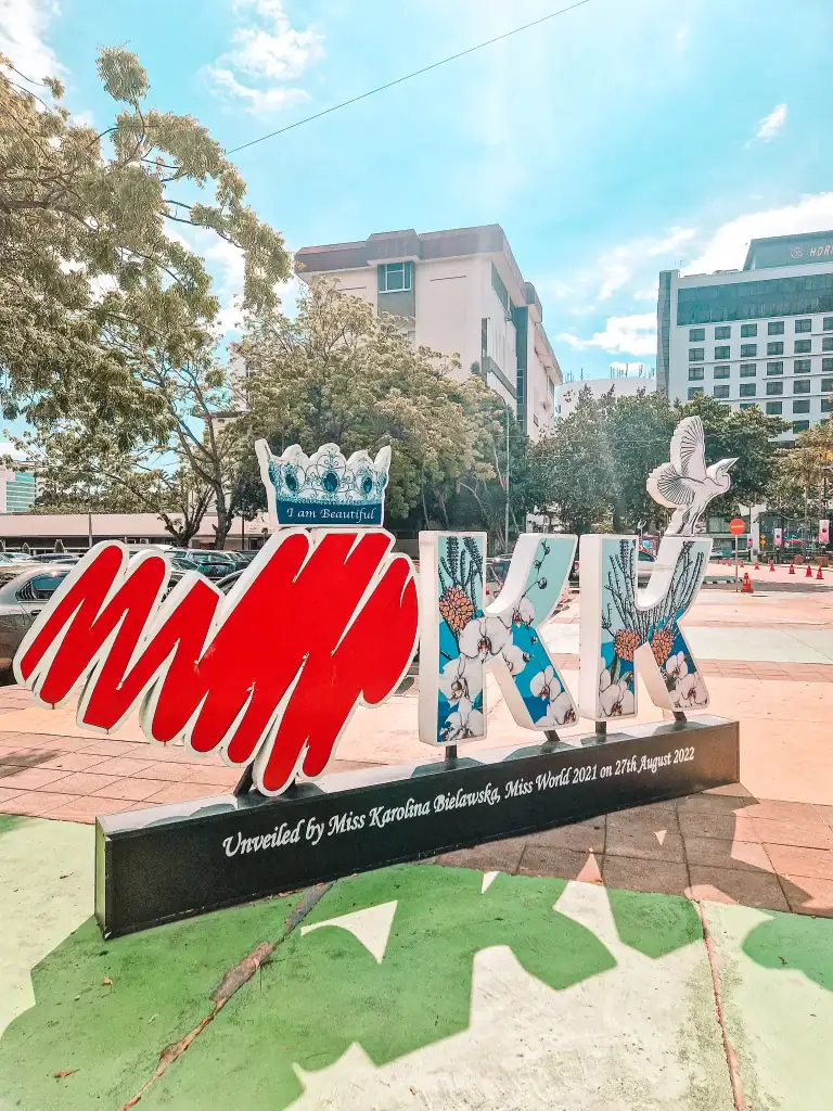 Colorful 3D "I am Beautiful KK" sign in downtown Kota Kinabalu, featuring floral designs and a crown detail, unveiled by Miss World 2021 — a fun and uplifting urban art stop.