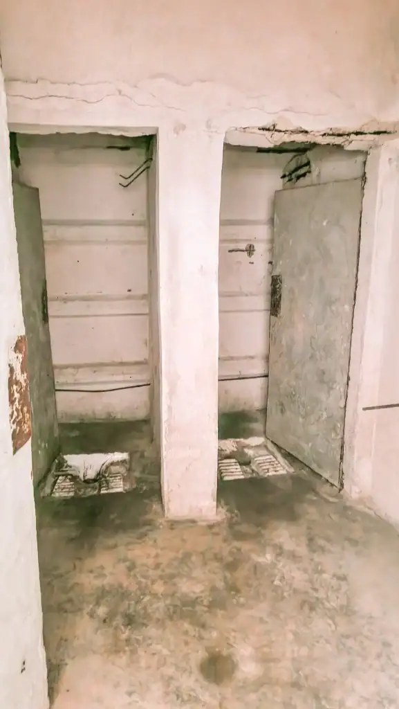 Two narrow, concrete squat toilets with chipped walls inside a Cold War-era bunker in Gjirokaster.