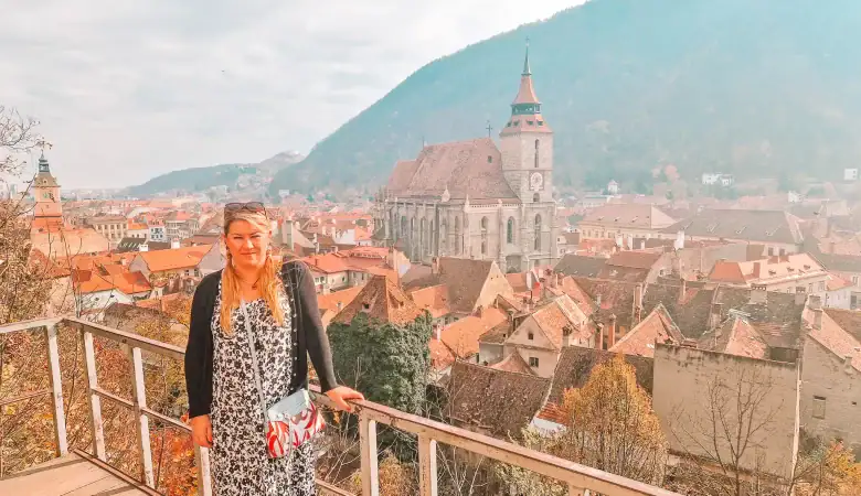 Em overlooks the city of Brașov from a viewing platform, with tiled rooftops, the Black Church, and forested hills stretching into the distance—a must-do for anyone seeking a panoramic perspective of the city.