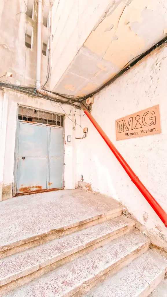 The modest entrance to the MiG Women’s Museum with a red pipe running alongside cracked white walls—an understated but important stop during 2 days in Tirana.