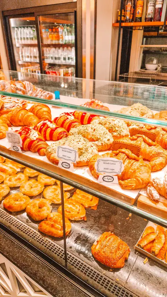 Glass display filled with colorful and decadent croissants at Nefeli, including Briosh Dubai and Briosh Lotus. A pastry lover’s dream that easily earns this spot a place among the best cafés in Tirana.