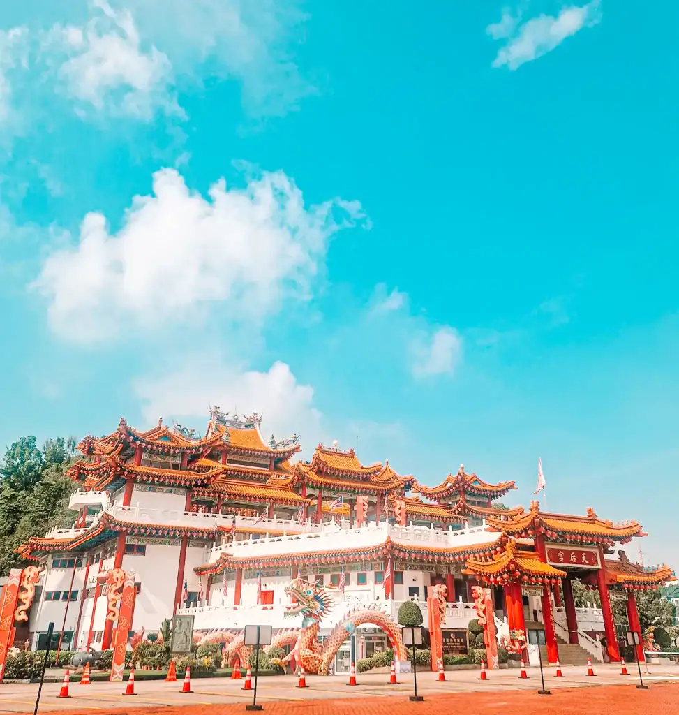 Thean Hou Temple in Kuala Lumpur stands out with its intricate red and gold architecture, dragon sculptures, and ornate rooftops under a vibrant blue sky—a must-see on a 3 week Malaysia itinerary.