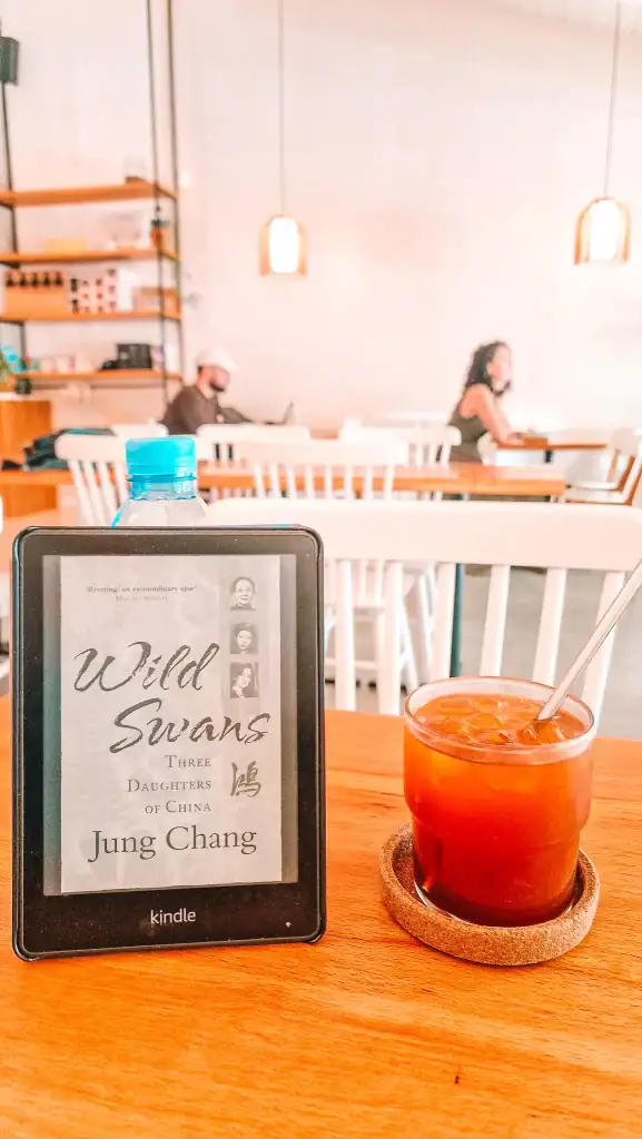 A Kindle showing Wild Swans, one of the most influential nonfiction books about China, in a quiet café setting.