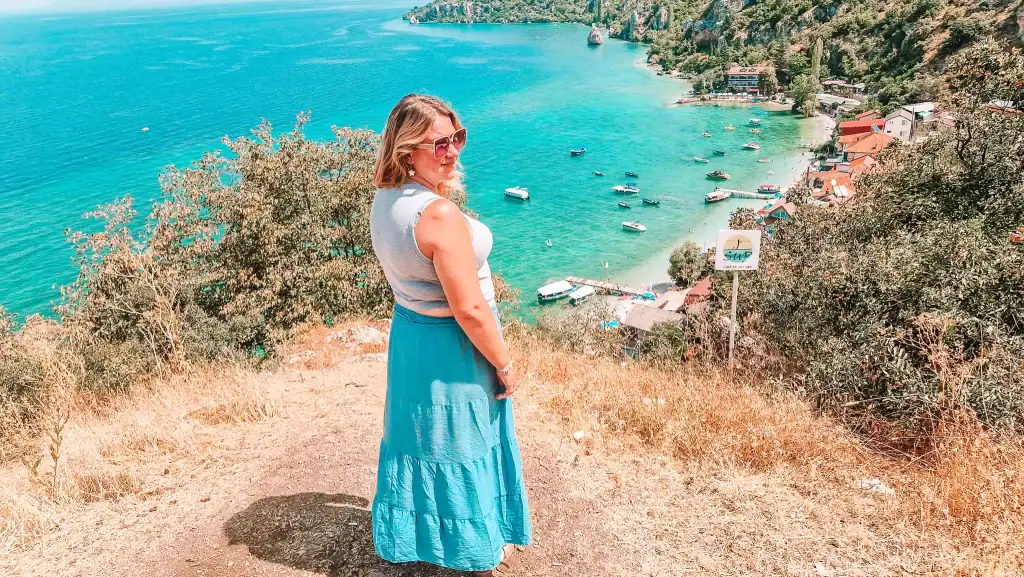Em overlooking the turquoise waters of Lake Ohrid in North Macedonia, with boats docked along the coast, showing why it’s a must-visit for lakeside relaxation and scenic villages.