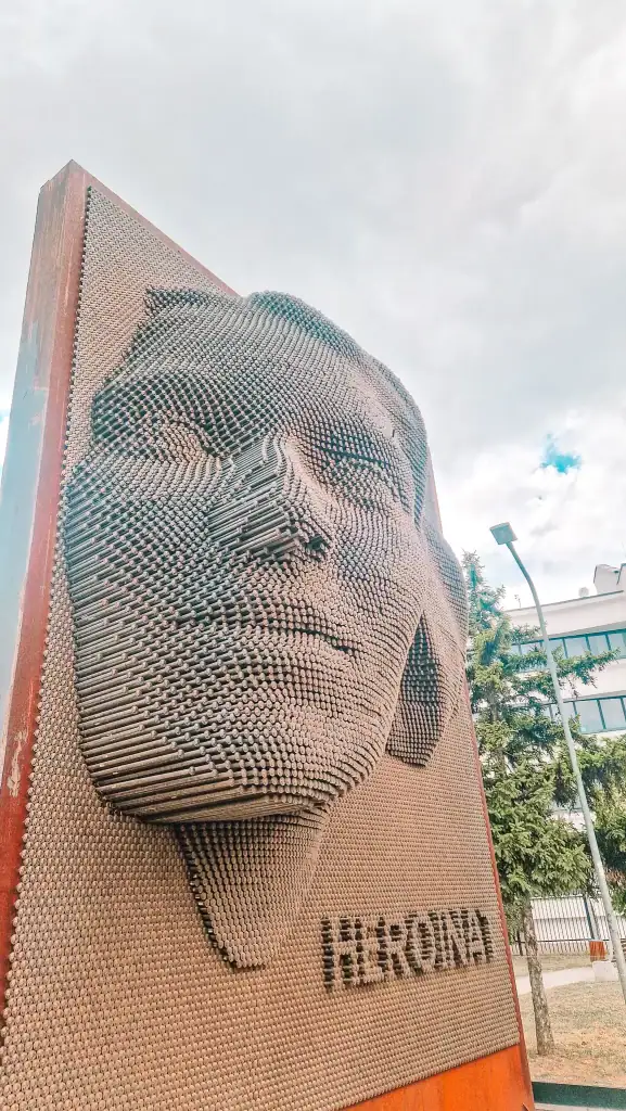 A close-up of the Heroinat Memorial in Pristina, a striking 3D face sculpture made of metal pins, honoring the women affected by the Kosovo War.