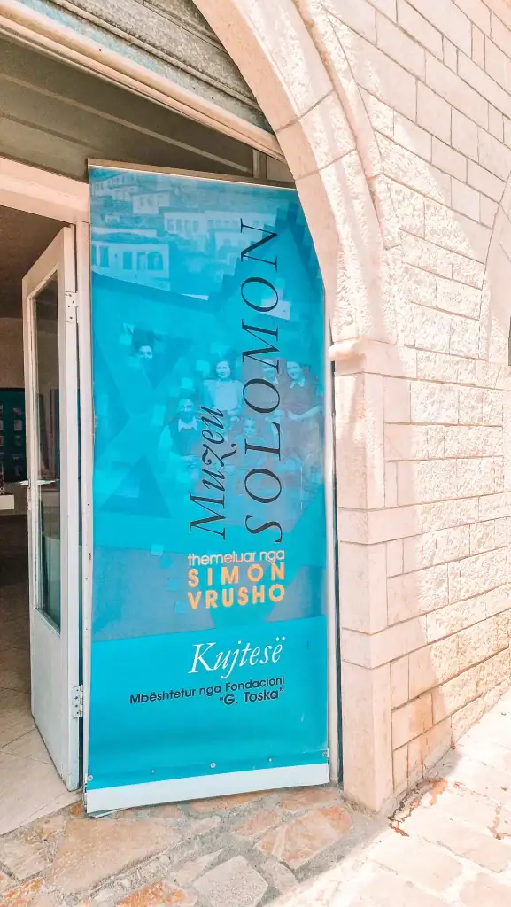 Blue banner at the doorway of the Solomon Museum, founded by Simon Vrusho, displayed on a stone arch entrance.