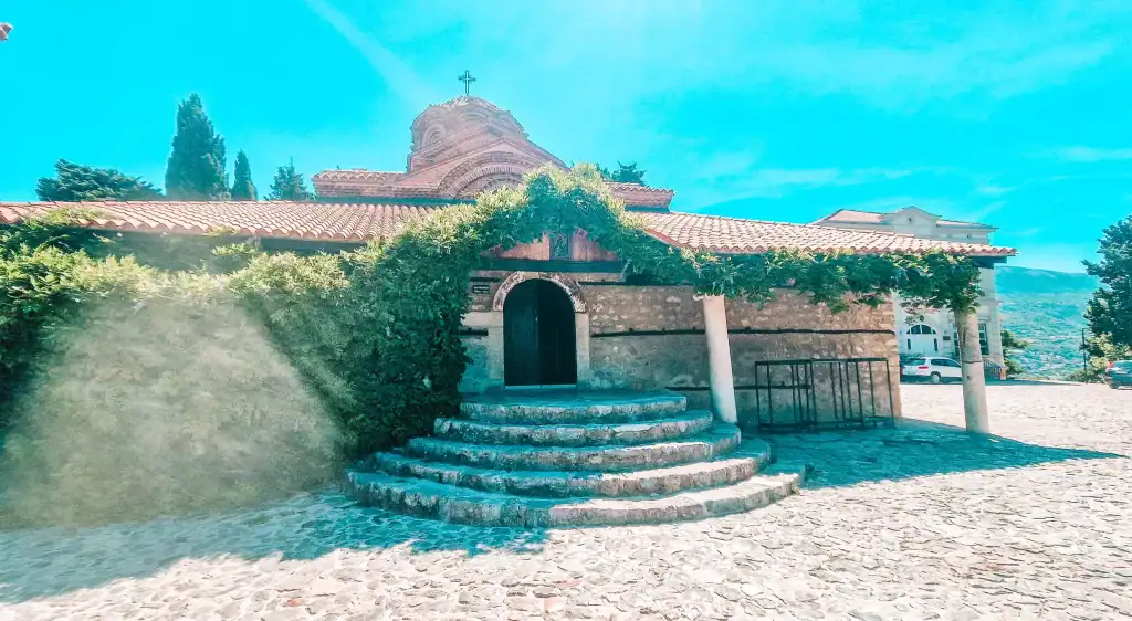 A quaint stone church in Ohrid, North Macedonia, with red roof tiles and ivy-wrapped columns, reflecting the town’s deep Orthodox heritage and ancient spiritual sites.