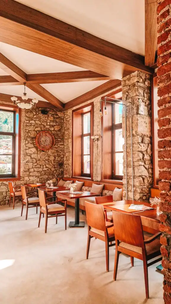 Cosy stone-walled restaurant interior with warm wooden furniture and soft lighting, ideal for a relaxed meal after exploring the sights of Krusevo.