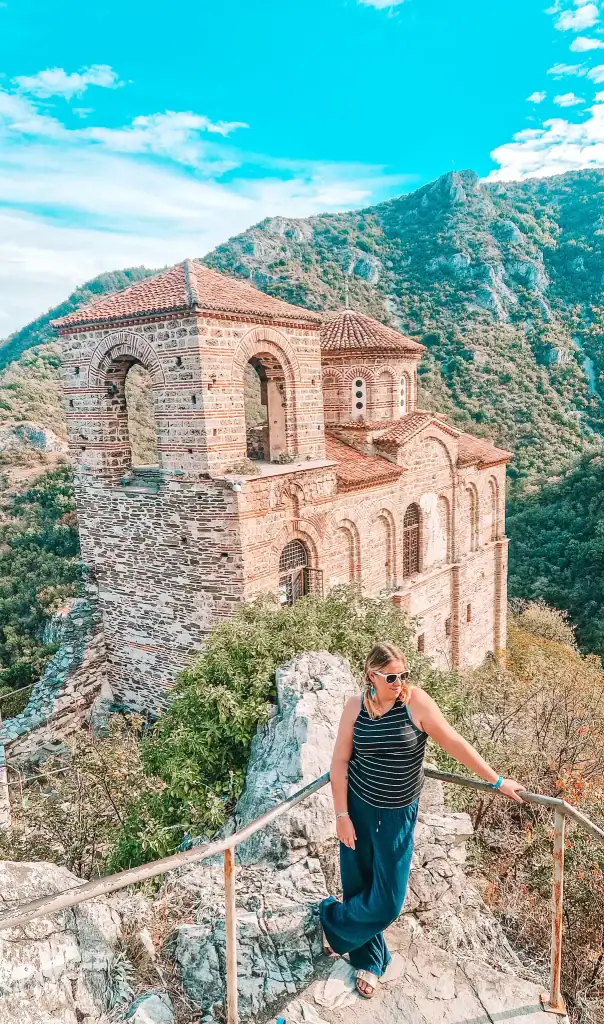 Em standing by the ruins of Asen’s Fortress, with the medieval church perched dramatically above the Rhodope Mountains.