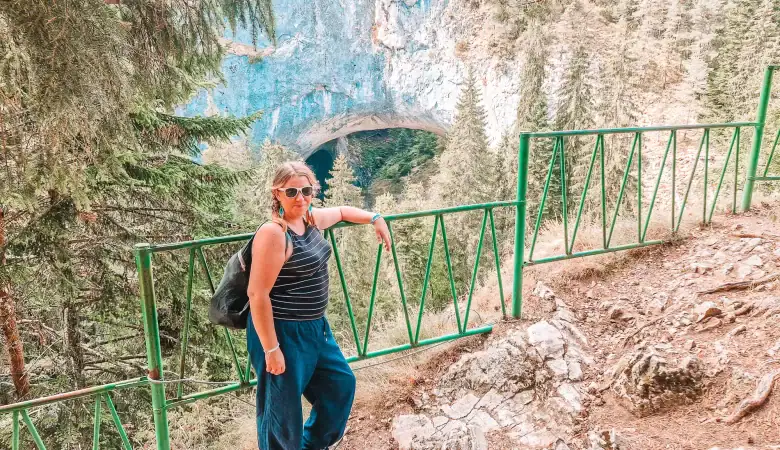 Em at the viewpoint overlooking the natural rock arch of the Wonderful Bridges, surrounded by pine forest in the Rhodope Mountains.