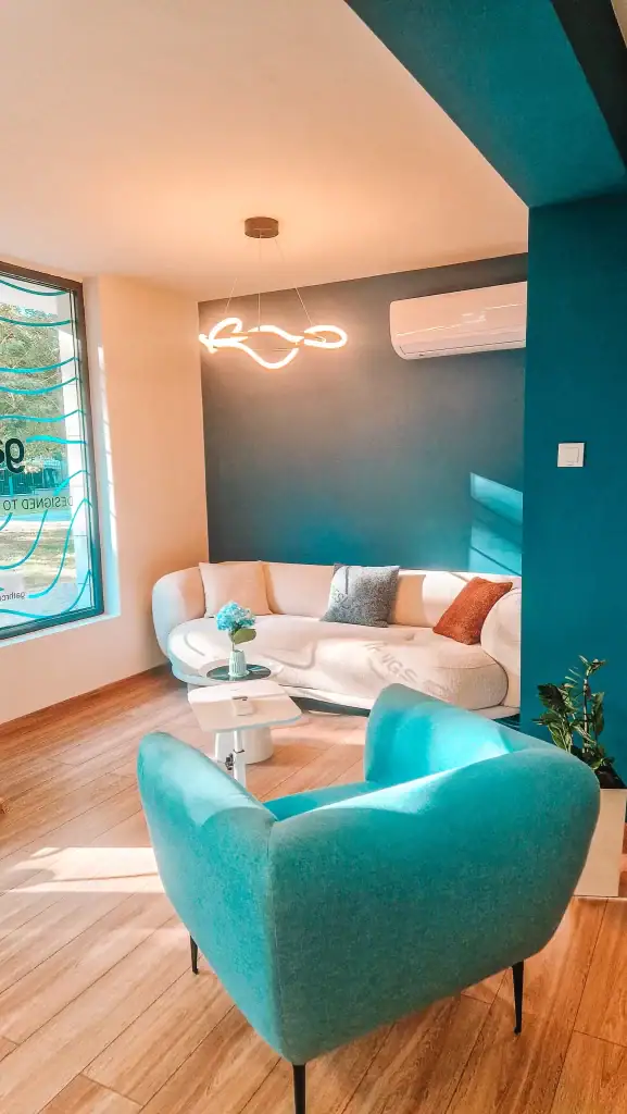 Another angle of a chic, light-filled café lounge in Plovdiv, featuring a curved sofa and modern lighting—designed with remote workers in mind.