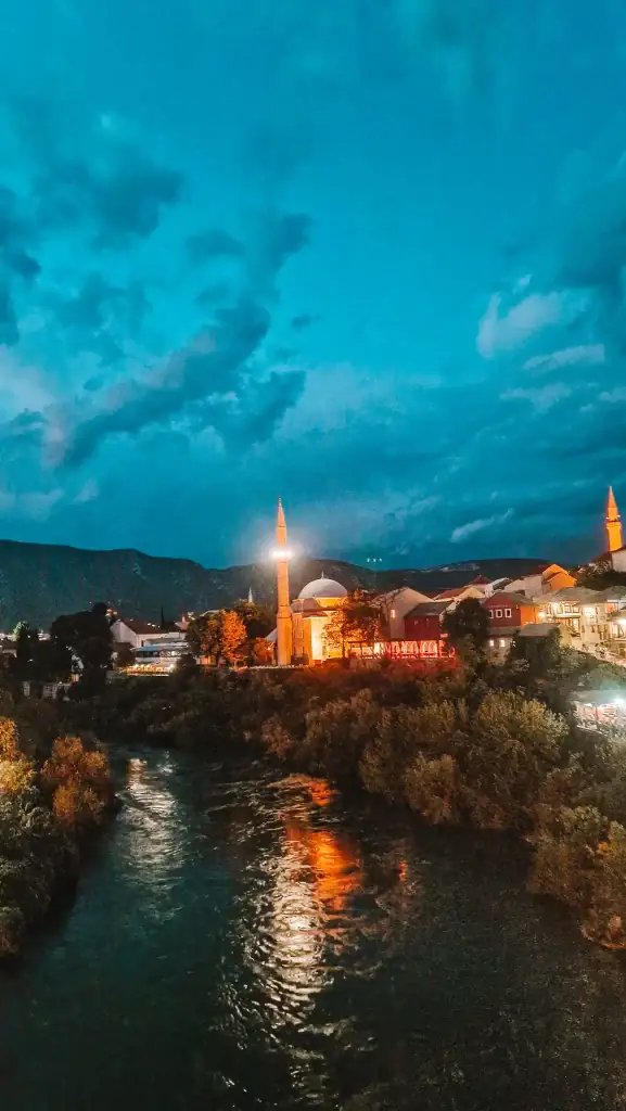 Nighttime view of Mostar’s old town with a lit-up mosque and its reflection glowing in the Neretva River. A serene and enchanting way to end a day of sightseeing.
