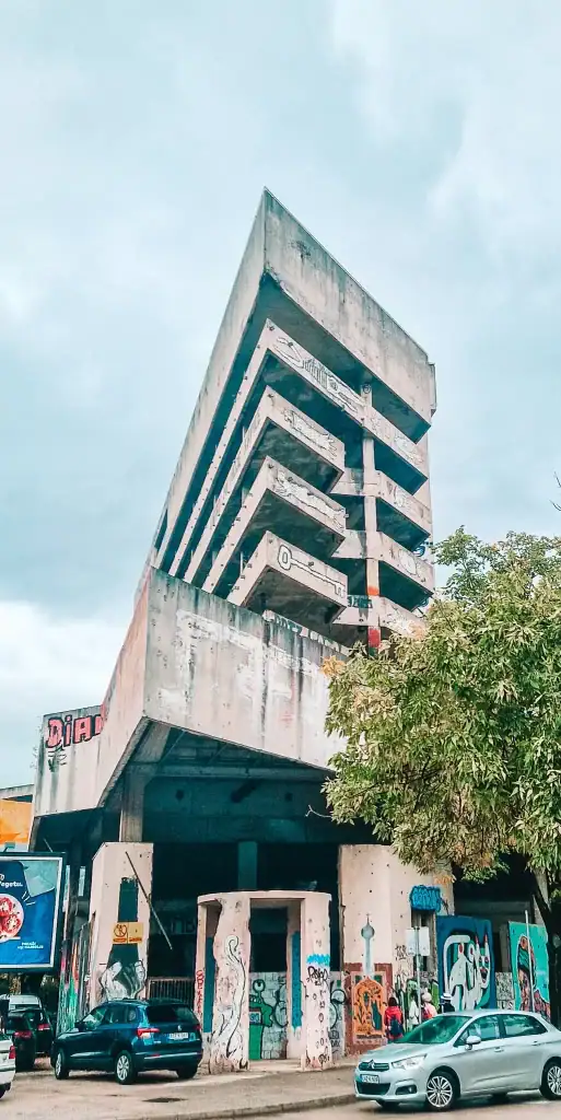 View of Mostar’s notorious former sniper tower, a tall concrete structure covered in graffiti and street art. A striking reminder of the city’s war-torn past and its creative urban revival.