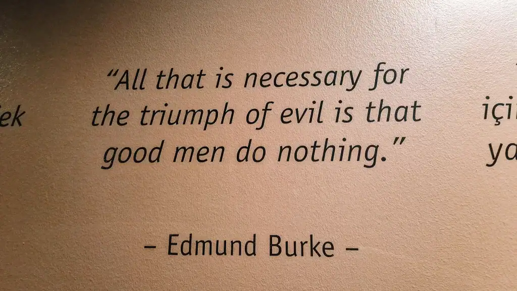 Wall with the quote “All that is necessary for the triumph of evil is that good men do nothing” by Edmund Burke displayed in bold black letters. A reflective moment captured from a museum dedicated to remembering war and human rights.