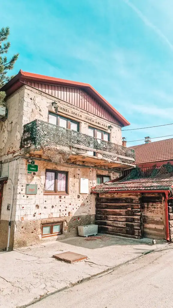 Exterior of the house marking the entrance to Sarajevo’s Tunnel of Hope, its walls peppered with wartime bullet holes and camo netting on the balcony. The house played a crucial role in providing supplies and escape during the siege of Sarajevo.