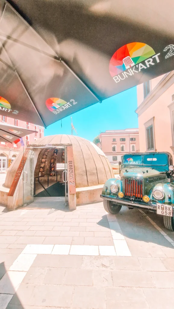 The entrance to “BunkArt 2” in Tirana with black branded umbrellas and a vintage military vehicle outside. This museum adds historical context to daily life in Albania’s capital.